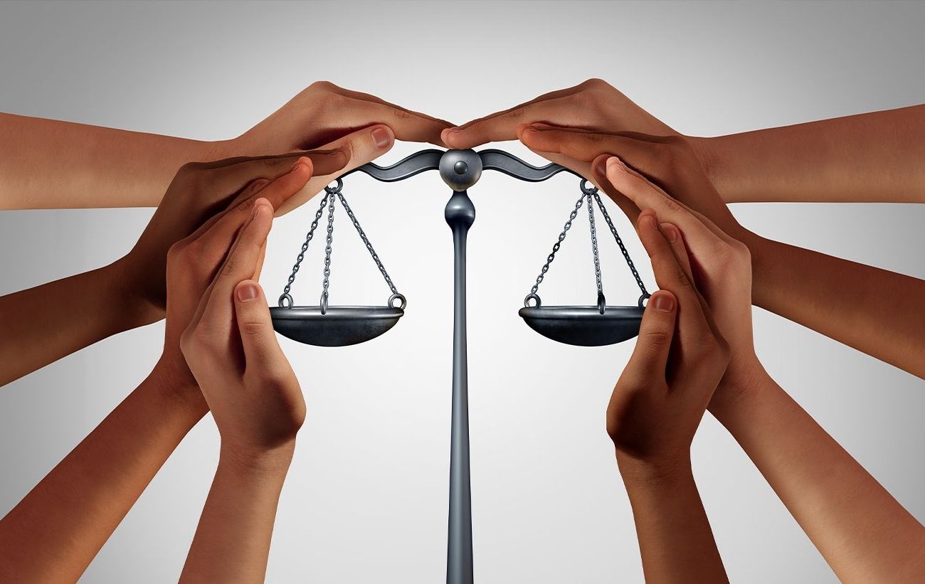 Schützende Hände über einer Waage in kreisform